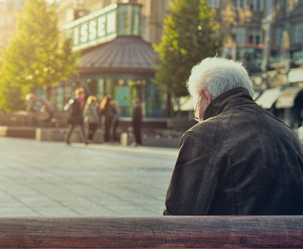 Man sitting on bench in town center